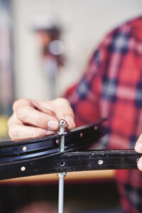 man threading a nut on to the end of a threaded rod pushed through a&hellip;